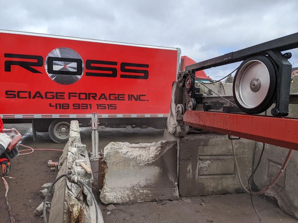Sciage mural avec lame diamant sur chantier — camion Ross Sciage Forage en arrière-plan